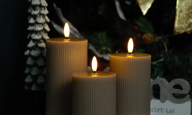 Mahogany teakwood candles glowing in a festive holiday setting